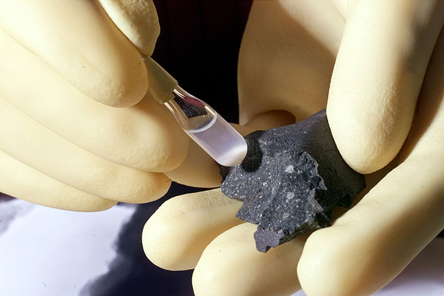 Fragment of the Murchison meteorite and isolated particles in the test tube (Image United States Department of Energy)